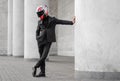 Beautiful motorcyclist in black suit and helmet with black visor