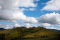 Beautiful mountain foothill, clouds and blue sky in the background. Mongolian mountain landscape on a cloudy day Royalty Free Stock Photo