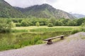 Beautiful mountain forest landscape. Bench by the lake overlooking the mountains Royalty Free Stock Photo