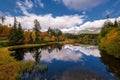 Beautiful mountain lake with a reflection of autum park on water and high peaks in the Background.