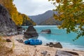 Beautiful mountain lake with turquoise water and pedal boat on the bank and colorful forest around. Royalty Free Stock Photo