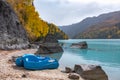 Beautiful mountain lake with turquoise water and pedal boat on the bank and colorful forest around. Royalty Free Stock Photo