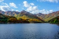 Beautiful mountain lake in the valley of the hills, in autumn, among thousands of colorful trees