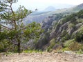 Beautiful mountain landscape with dangerous with sloping rocks in spring. Green trees on the rocks. Mountain ranges in a blue haze Royalty Free Stock Photo