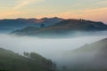 Beautiful mountain landscape of a foggy morning with a colorful sky and trees Royalty Free Stock Photo