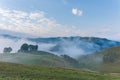 Beautiful mountain landscape of a foggy morning with and old house, trees and clouds Royalty Free Stock Photo