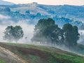 Beautiful mountain landscape of a foggy morning with and old house and trees Royalty Free Stock Photo