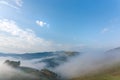 Beautiful mountain landscape of a foggy morning with trees and clouds Royalty Free Stock Photo