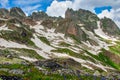 Beautiful mountain landscape with green slopes, flowers and snow Royalty Free Stock Photo