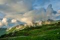 Beautiful mountain landscape with green slopes and snow and clouds Royalty Free Stock Photo