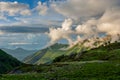 Beautiful mountain landscape with green slopes and snow and clouds Royalty Free Stock Photo