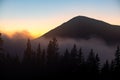 Beautiful mountain landscape with hazy peaks and foggy wooded valley at sunset Royalty Free Stock Photo