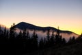 Beautiful mountain landscape with hazy peaks and foggy wooded valley at sunset Royalty Free Stock Photo