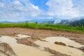 Muddy road along mountain meadow, bright blue sky over mountains. Carpathians. Royalty Free Stock Photo