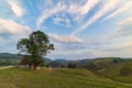 Beautiful mountain landscape with and old house, trees and a cloudy morning sky Royalty Free Stock Photo