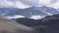 Beautiful mountain landscape with rocky snow ridges and low clouds. Clip. Vapors in foothills and low clouds over snow Royalty Free Stock Photo