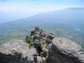 Beautiful mountain landscape with rounded rocks. Top view of the inhabited valley with lake. Distant mountain plateaus in a blue Royalty Free Stock Photo