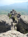 Beautiful mountain landscape with rounded rocks. Top view of the inhabited valley. Distant mountain plateaus in a blue haze and Royalty Free Stock Photo