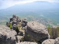 Beautiful mountain landscape with rounded rocks. Top view of the inhabited valley with lake. Distant mountain plateaus in a blue Royalty Free Stock Photo