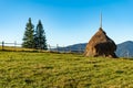 Beautiful mountain landscape with traditional piles of hay on meadow in Romania Royalty Free Stock Photo