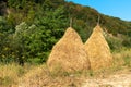 Beautiful mountain landscape with traditional piles of hay on meadow in Romania Royalty Free Stock Photo