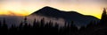 Beautiful mountain panorama of landscape with hazy peaks and foggy wooded valley at sunset Royalty Free Stock Photo