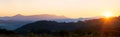 Beautiful mountain panorama of landscape with hazy peaks and foggy wooded valley at sunset Royalty Free Stock Photo