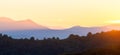 Beautiful mountain panorama of landscape with hazy peaks and foggy wooded valley at sunset Royalty Free Stock Photo