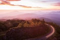 Beautiful mountain road at sunrise, curve asphalt road with light trail from headlights leading through mountain range. Doi Royalty Free Stock Photo