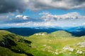 A beautiful mountain scenery. A dramatic, blue sky with many clouds. The heights of the mountains covered with green grass and Royalty Free Stock Photo