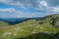 A beautiful mountain scenery. A dramatic, blue sky with many clouds. The heights of the mountains covered with green grass and Royalty Free Stock Photo