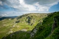 A beautiful mountain scenery. A dramatic, blue sky with many clouds. The heights of the mountains covered with green grass and Royalty Free Stock Photo