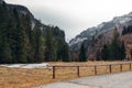 Beautiful mountain valley in early spring. Dirt road and wooden railings in the foreground. Crocuses in the meadow. Mountain peak Royalty Free Stock Photo