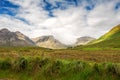 Beautiful mountains in Connemara, county Galway, Ireland; Warm sunny day, Clouds over peaks, Vast green fields