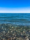 Beautiful multi-colored round stones on the sea, rivers, lakes, pond, ocean and boiling water with waves on the rocky beach Royalty Free Stock Photo