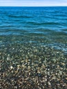 Beautiful multi-colored round stones on the sea, rivers, lakes, pond, ocean and boiling water with waves on the rocky beach Royalty Free Stock Photo