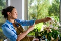 Female florist photographing a floral arrangements in wicker basket for wedding Day, working with orders in floral shop