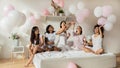 Beautiful multiethnic ladies having fun with pink balloons in bedroom Royalty Free Stock Photo