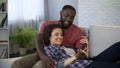 Beautiful multiracial couple having pleasant pastime together at home, marriage