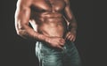 Beautiful muscular male model with nice abs in jeans. Athletic man with ab, abs or six pack. Chest muscles. Male torso. Royalty Free Stock Photo