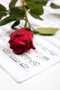 Beautiful music. Cropped shot of a red rose lying atop sheet music. Royalty Free Stock Photo