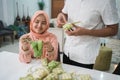 beautiful muslim couple asian making ketupat rice cake at home