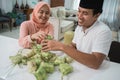 beautiful muslim couple asian making ketupat rice cake at home