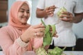 beautiful muslim couple asian making ketupat rice cake at home