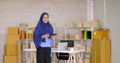 Muslim female merchandiser doing online marketing at the office