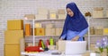 Muslim female merchandiser preparing parcel at the office
