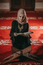 Musliim girl reading Quran in mosque