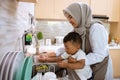 muslim mother wash her son hand in the kitchen sink Royalty Free Stock Photo