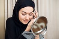 Beautiful muslim woman applying eyeshadow eyeliner at home Royalty Free Stock Photo