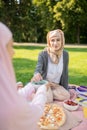 Beautiful muslim woman eating yummy lunch with friend